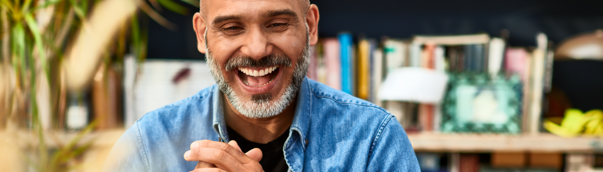 Man smiling at computer screen during remote meeting