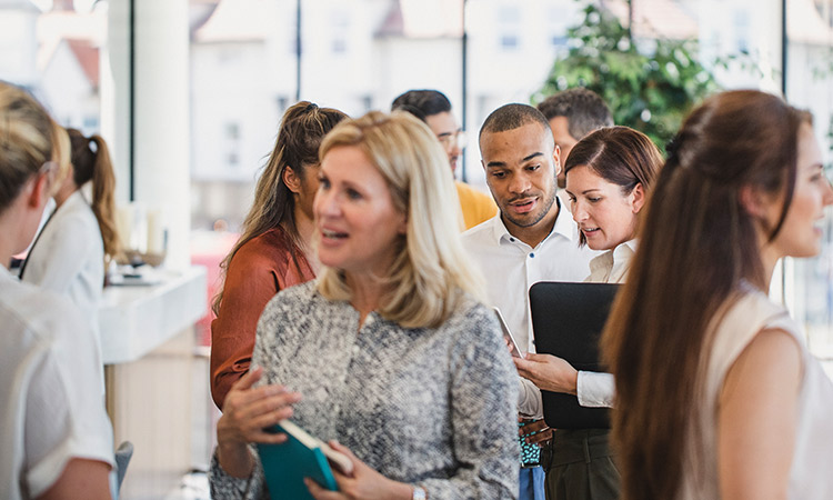 Group of delegates in conversation at event.